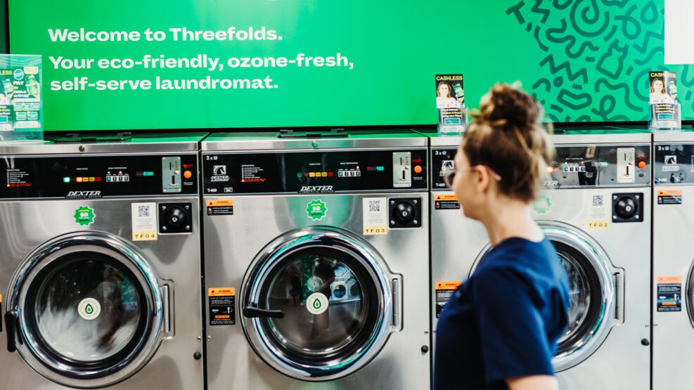 Woman infront of Threefolds' laundry machines
